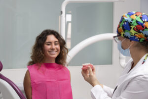 Paciente sonriente en consulta con su dentista en Castellón, recibiendo asesoramiento sobre salud bucodental.