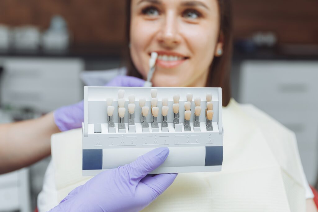 Paciente en clínica dental eligiendo el color del diente para su implante en Castellón