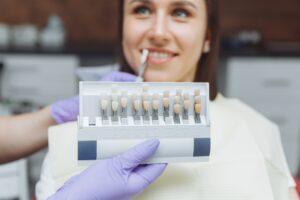 Paciente en clínica dental eligiendo el color del diente para su implante en Castellón